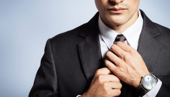 Man in suit fixing his tie